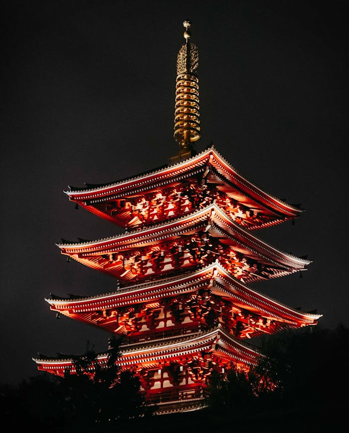 A beautifully lit traditional Japanese pagoda at night in Tokyo, showcasing vibrant architecture.